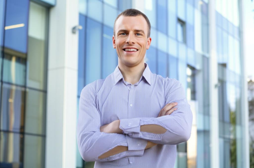 A smiling man, looking energetic and confident, standing in front of his office building.
