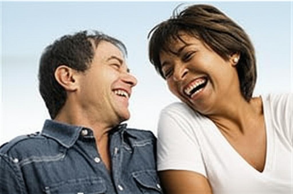 Happy couple laughing together, looking relaxed and intimate