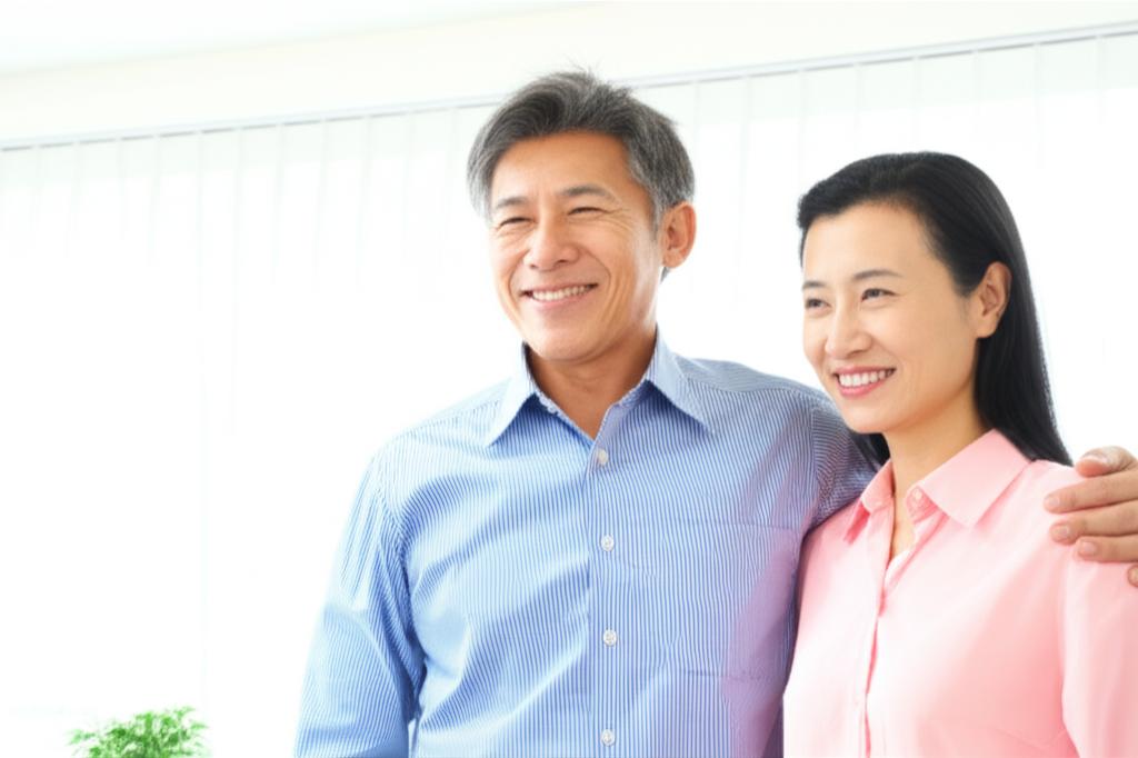 middle-aged asian man smiling confidently with his wife